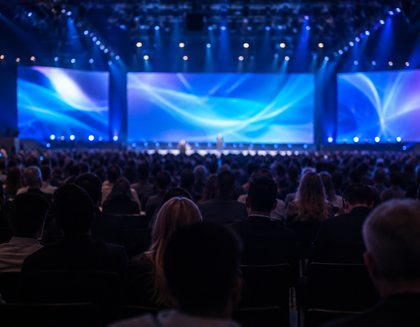 A conference audience facing a lit stage